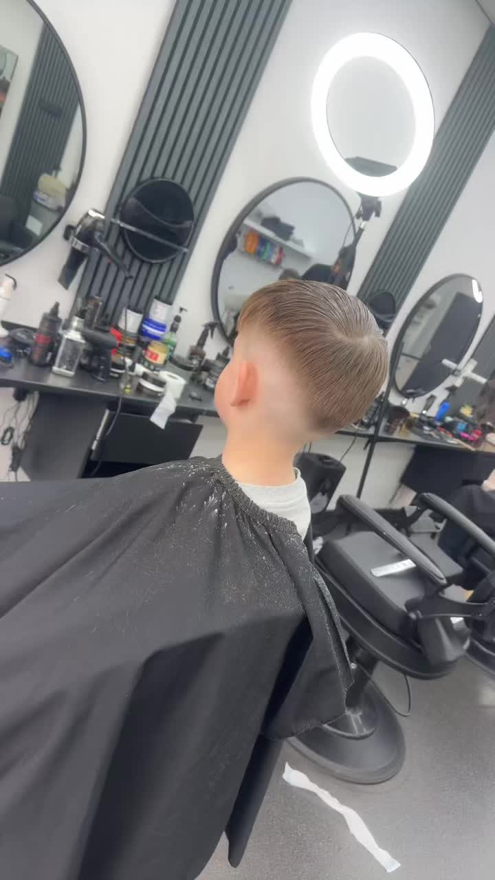 Mid fade van achteren, met de spiegels en de lamellenwand van de zaak
